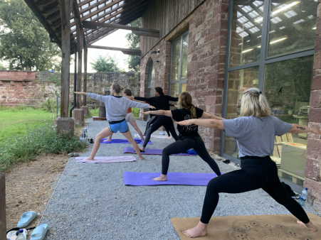 Bild von der Summer School, auf welchem Menschen Yoga machen.